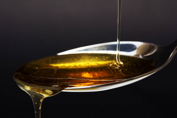 istock Honey pouring from spoon against a dark background 648979052