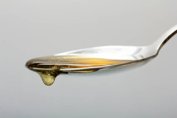 istock Honey pouring from spoon against a light background 648979066