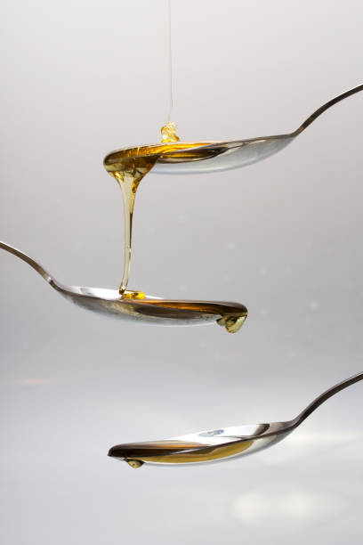 istock Honey pouring from spoon against a light background 648979072