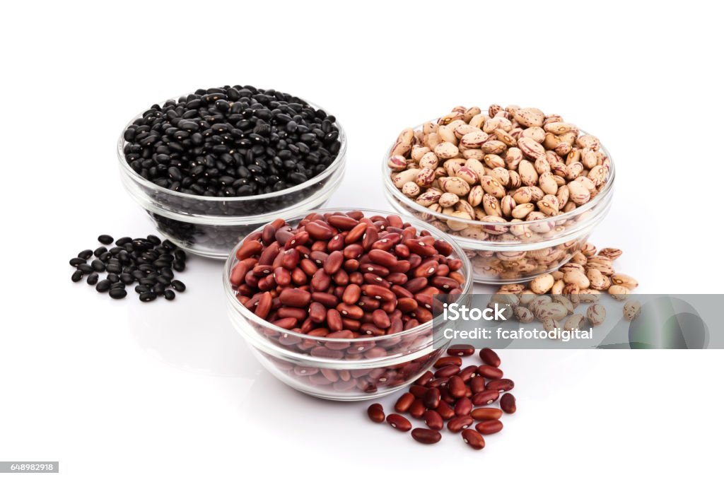 Three kinds of beans on white background Three glass bowls filled with beans isolated on white background. Some beans are out of the bowls directly on the white background beside it. DSRL studio photo taken with Canon EOS 5D Mk II and Canon EF 100mm f/2.8L Macro IS USM Bean Stock Photo