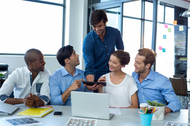 istock Team of graphic designers discussing over digital tablet 648983696