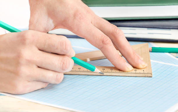 istock Female hand holding pencil and drawing over graph paper. 648983758