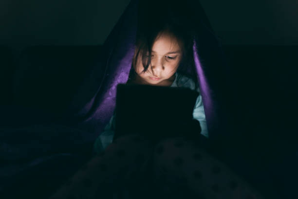 istock Little girl using tablet under the blanket 648983966