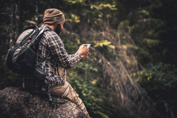 istock Traveler using a smart phone in the forest 648986298