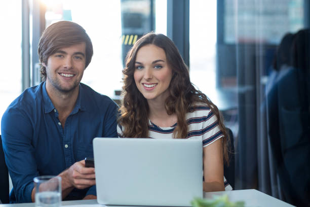 istock Male and female business executive using mobile phone 648989742