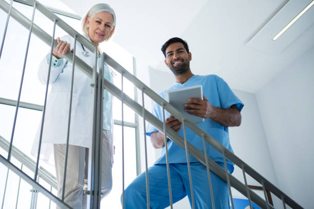 istock Portrait of doctors smiling while standing on staircase 648990904