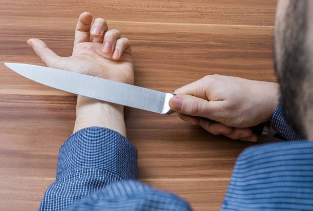 istock Young man wants to commit suicide by cutting vein on hand with knife. 649000652