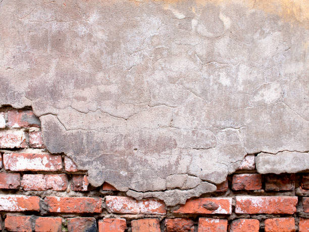 istock Damaged brick wall with peeling plaster background for design 649003290