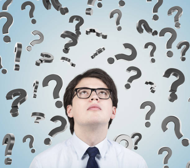 istock Man in glasses and question marks on gray 649009620