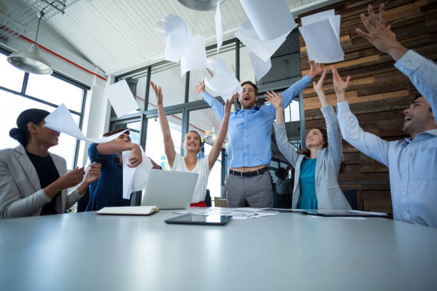 istock Team of graphic designers throwing documents up in air 649012570