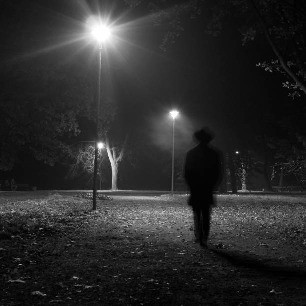 istock Surreal man walking in the park at night. 649013034