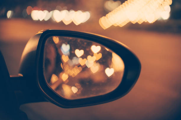 Abstract: Love Concept, Heart Bokeh background in vintage filter from car side mirror.