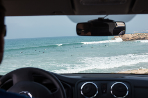 Looking through the front car window searching for surfing waves