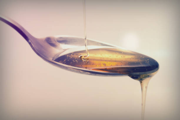 istock Honey pouring from spoon against a light background 649019494