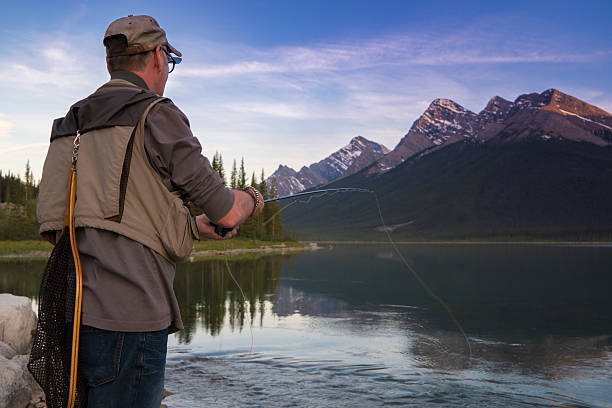istock Fly fisherman casts line into mtn lake, inlet 649035859