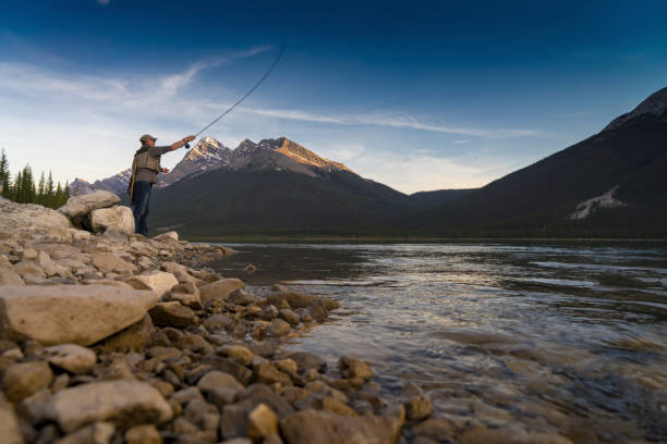istock Fly fisherman casts line into mtn lake, inlet 649035863