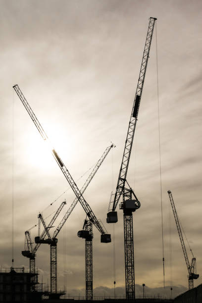 cranes silhouette on construction site - tower steel mansion investment imagens e fotografias de stock
