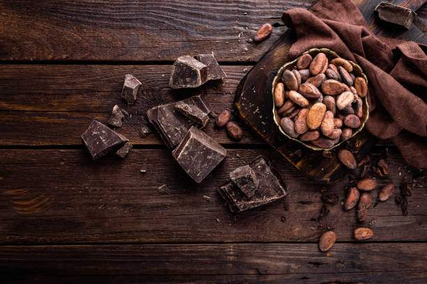 granos de cacao y chocolate sobre fondo de madera - chocolate beans fotografías e imágenes de stock