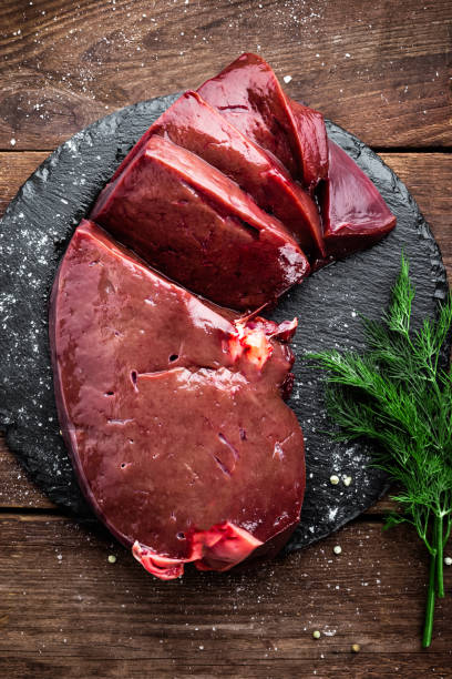 istock Raw liver on slate board on wooden background top view 649046194