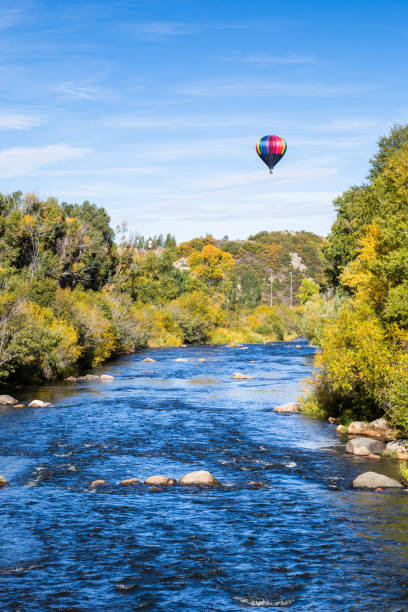 globo de aire caliente sobre río azul y los árboles cambiando de color aún mañana de otoño - heat mid air flying float fotografías e imágenes de stock