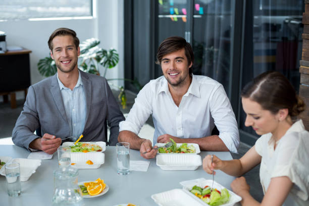 istock Smiling business executive having meal in office 649067096