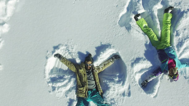 istock Couple making angel silhouette in snow 649074334