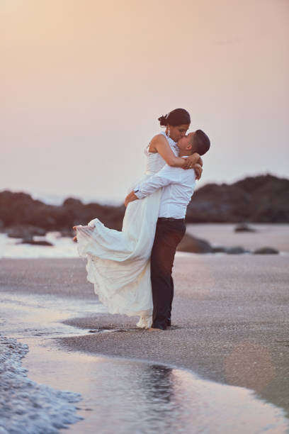 szczęśliwy całowanie pana młodego i panny młodej - wedding beach bride groom zdjęcia i obrazy z banku zdjęć