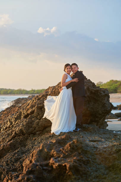 istock Hugging bride and groom standing on rock 649074826