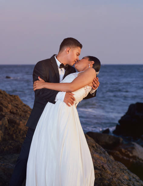 istock Bride and groom kissing on beach 649074838