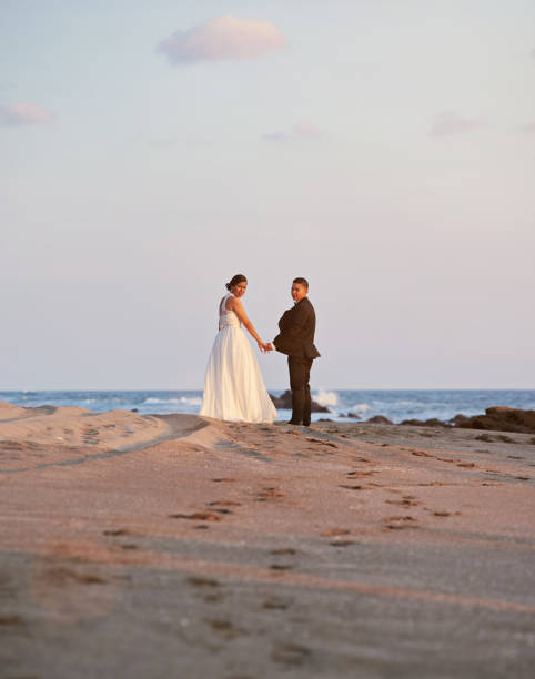 istock Bride and groom walking on tropical beach 649074886