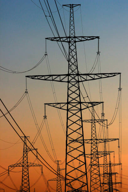 istock Power line pylons against sunset sky background 649078644