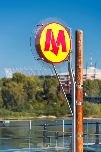 Warsaw metro sign, on the background Vistula river and