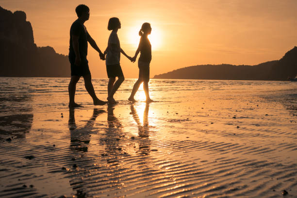 istock happy family walking on the beach 649087658