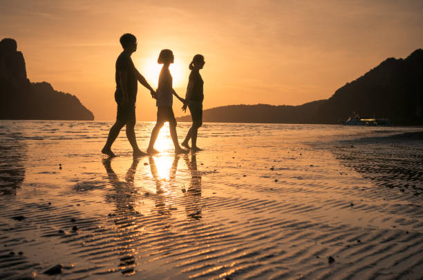 istock happy family walking on the beach 649087664