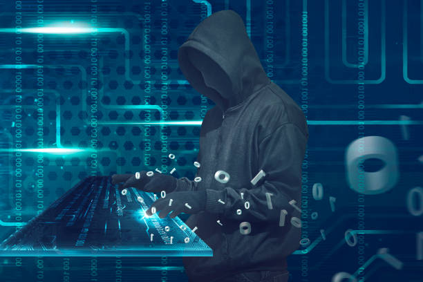 istock Hooded man with anonymous mask typing on virtual keyboard 649087770