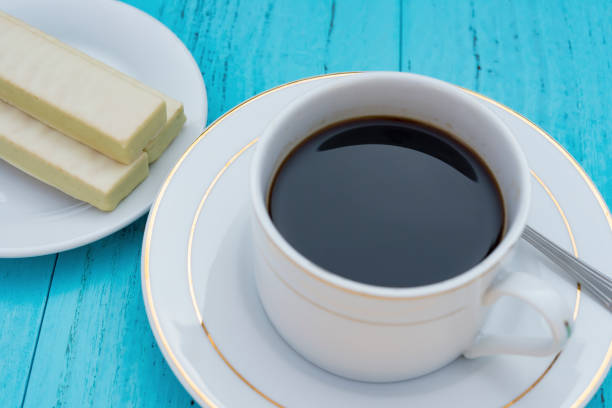 istock cup of coffee and white chocolate wafer on blue ackground 649094914