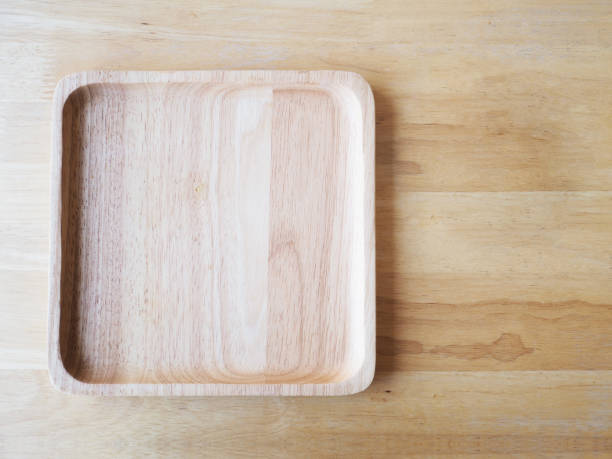 istock Wooden square plate on wood background, top view. 649101158