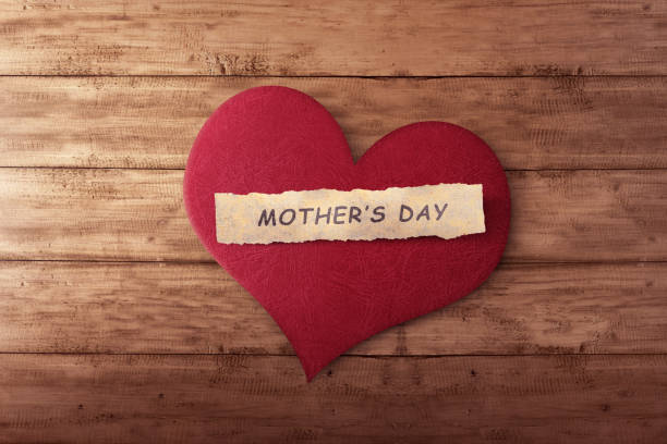 istock Mother's day message on ripped paper in red heart shape 649106954