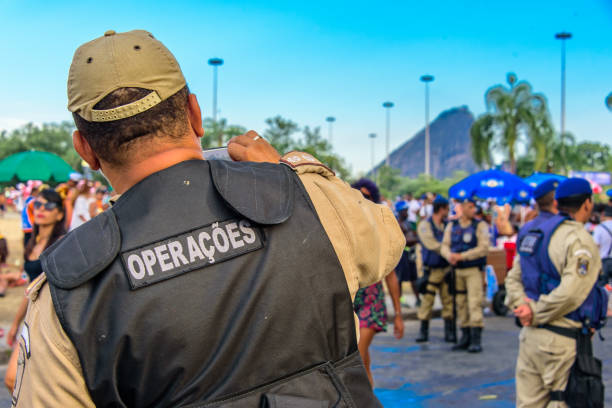 retour du policier prenant des photos de gens costume au bloco orquestra voadora dans le parc de flamengo, carnaval 2017 - parc flamengo photos et images de collection