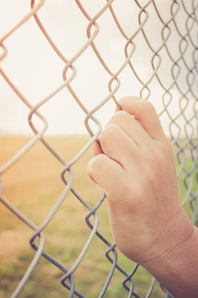 istock hand holding on chain link fence 649115244