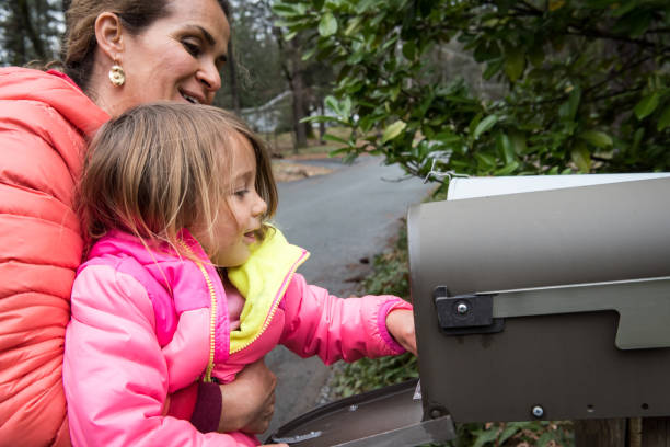 little girl checking a mailbox - looking into mailbox imagens e fotografias de stock