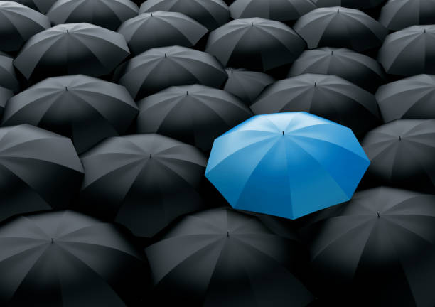 Standing out of the crowd Unique and different blue umbrella standing out of the crowd from black ones graphite photos stock pictures, royalty-free photos & images