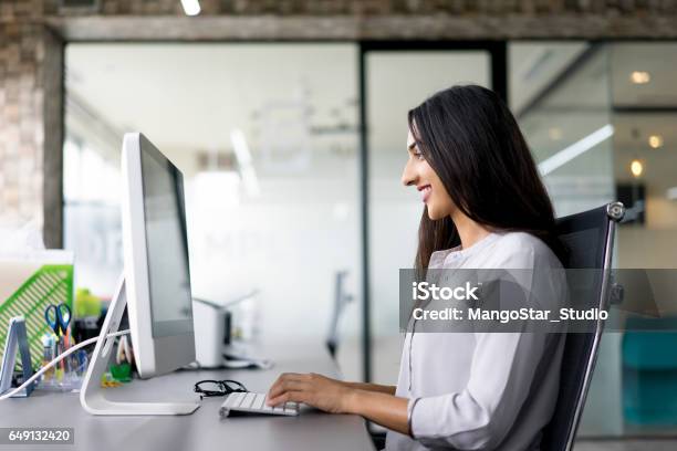 Smiling Young Businesswoman Typing On Computer Stock Photo - Download Image Now - Indian Ethnicity, Office, Desk