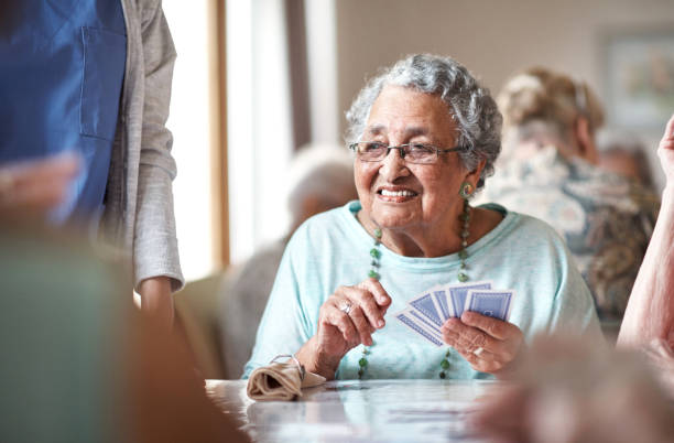 ha una grande mano e lei lo sa - nursing home senior adult group of people home caregiver foto e immagini stock