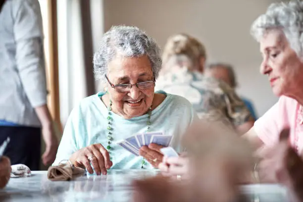 Shot of a group of seniors playing a board game in their retirement home