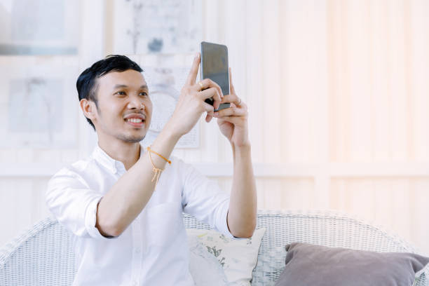 istock Asian man using a mobile phone  in  bakery shop. 649148964