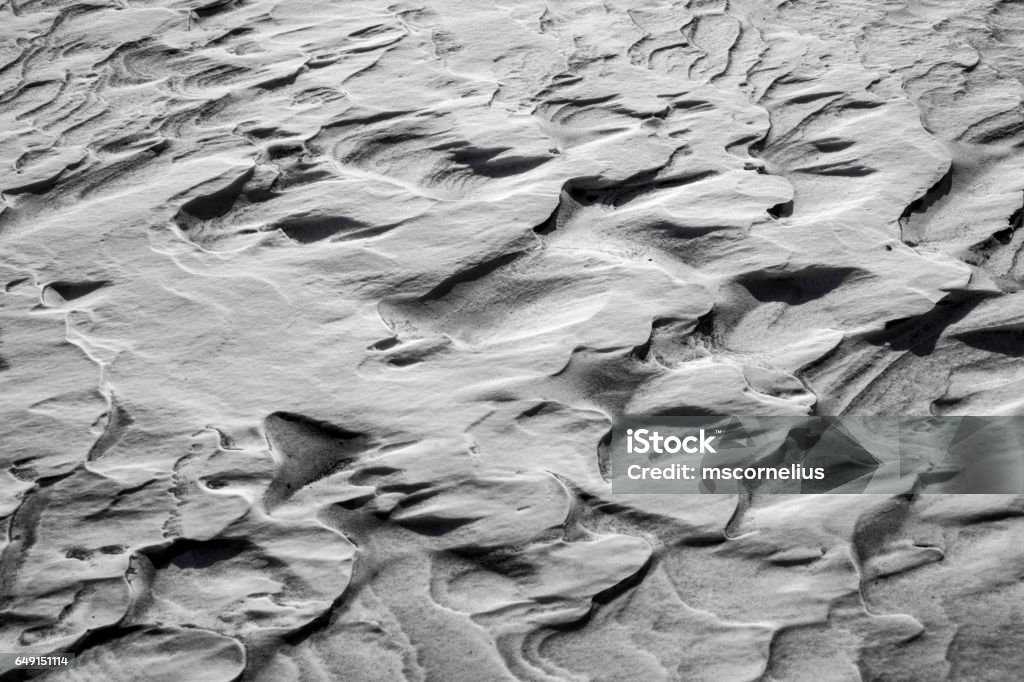 Wind sculpted snow Patterns formed by wind on snow in black and white. Abstract Stock Photo