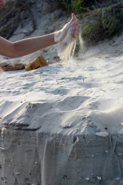 istock Sand from female hands crumbles in the wind 649156464
