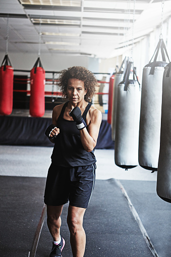 Cropped shot of a female kick-boxer training at the gym