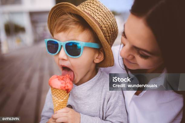 Schattige Jonge Jongen Eten Van Ijs In Zijn Moeders Armen Stockfoto en meer beelden van Roomijs